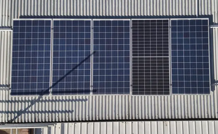 Blue solar panels are installed on a gray roof