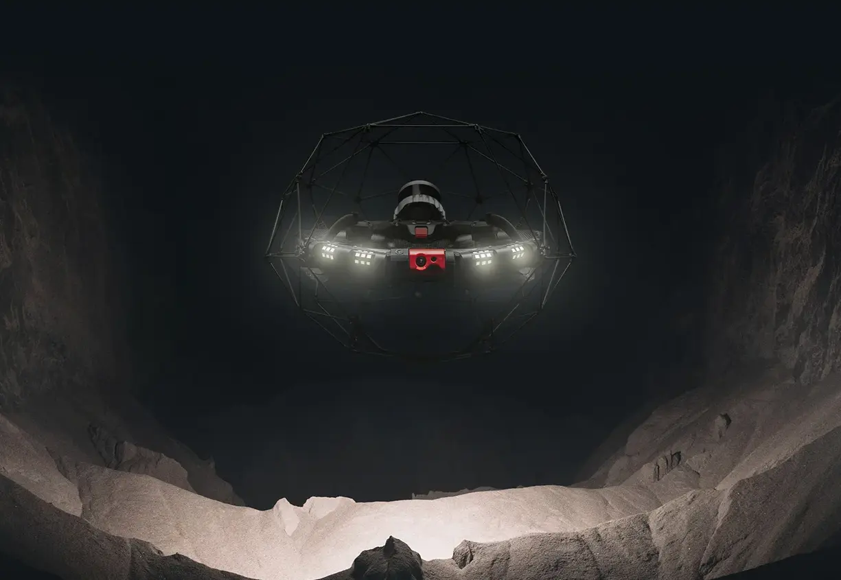 A black drone is conducting an inspection in a dark underground area
